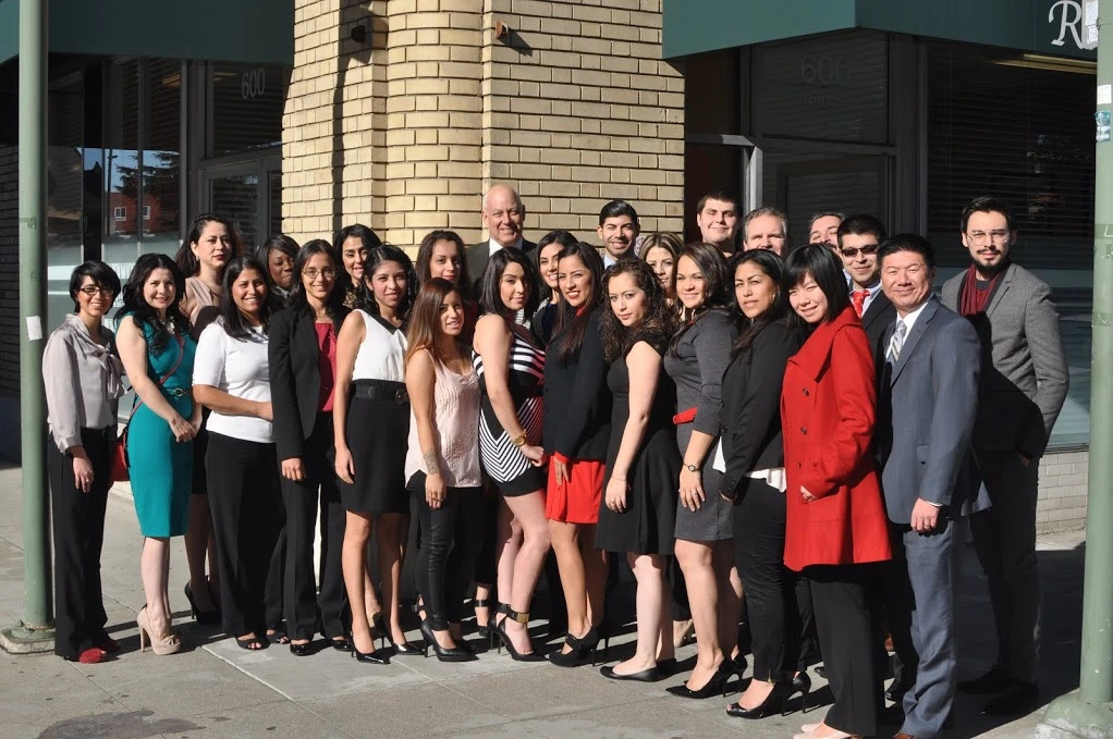 Business professionals from Ratto Law Firm smiling together for a group photo in formal attire