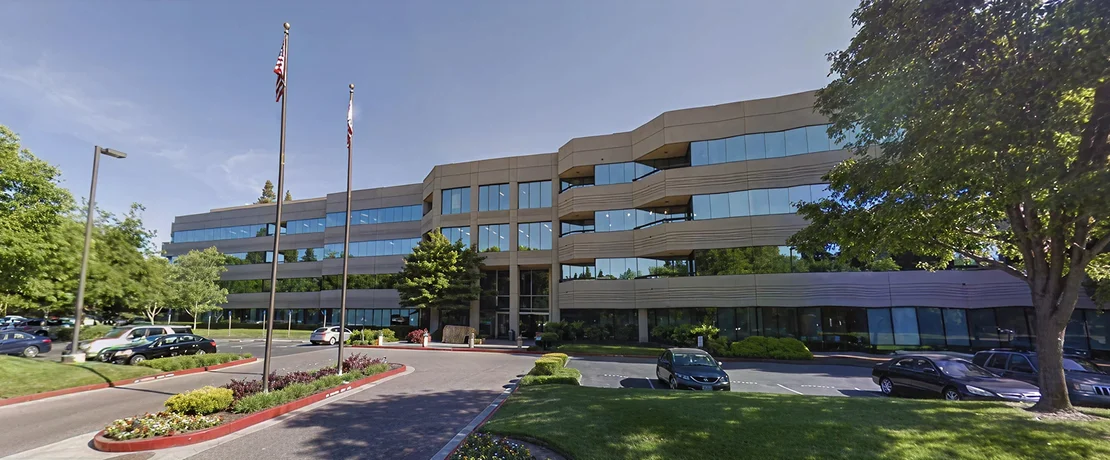 a building with a flag pole and grass