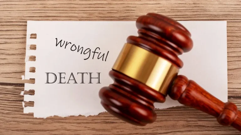 Wooden judge's gavel resting on paper with the words "wrongful death" on a wooden surface.